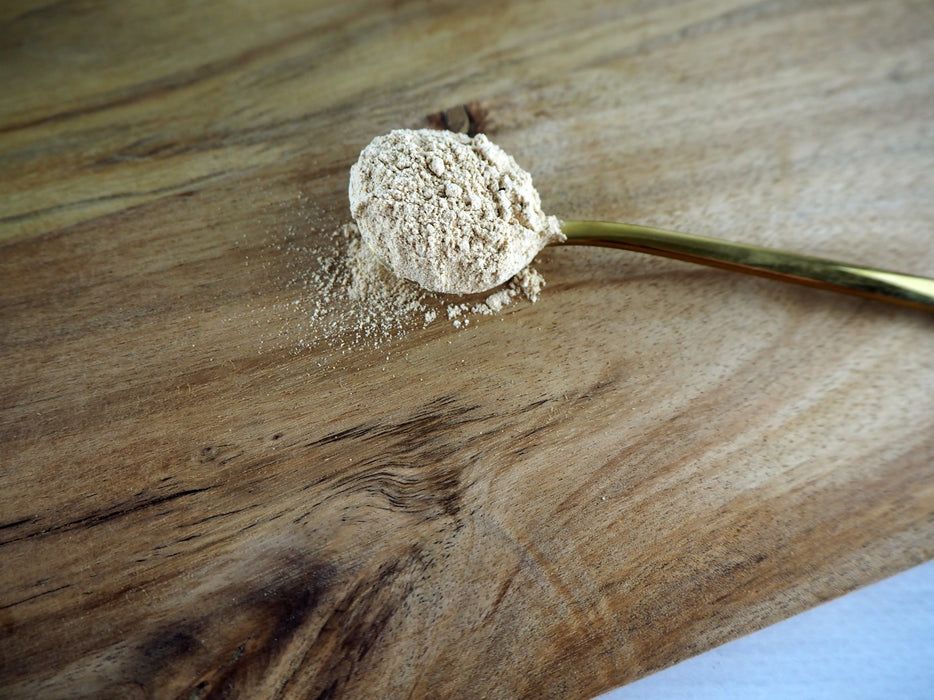 Schüssel mit Bio Maca Pulver auf einem dunkelblauen Tuch, hervorgehoben als Teil einer gesunden Ernährung.